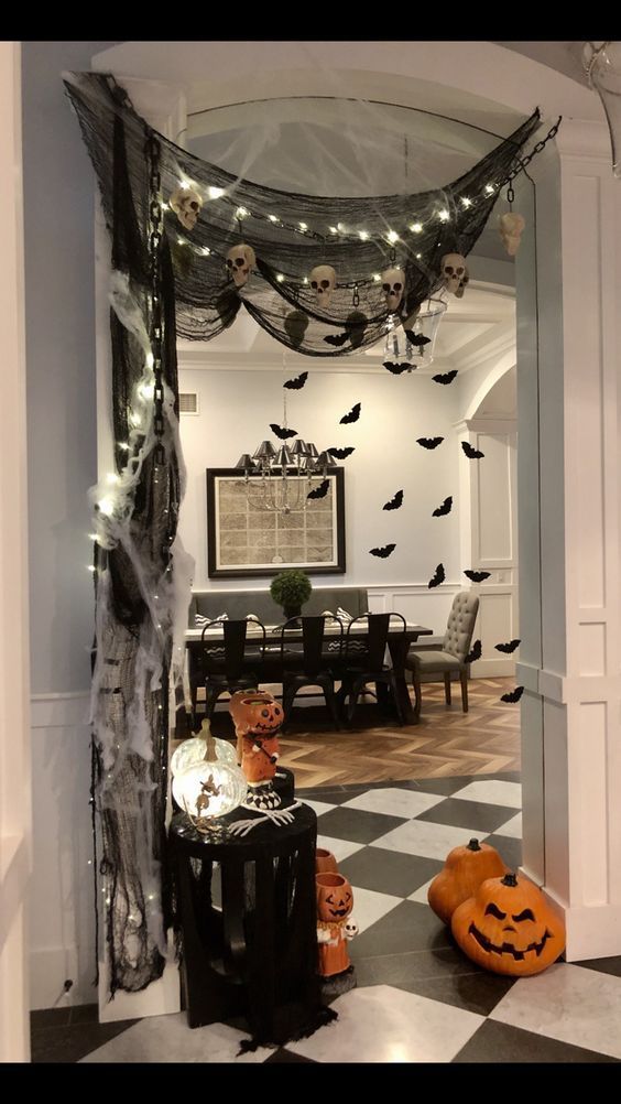 halloween decorations in the entry way of a house with black and white checkered flooring