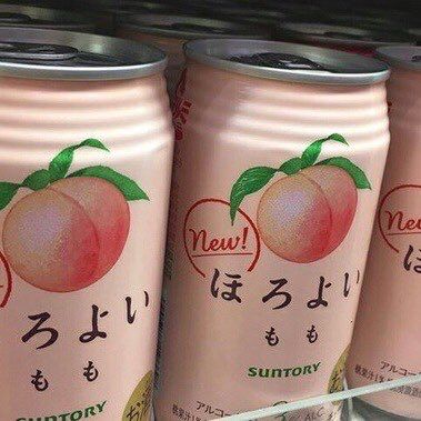 four cans of peach tea are on display in a store shelf with japanese writing and symbols