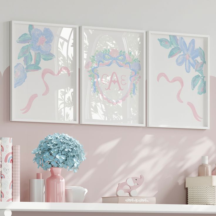 two pink flamingos are hanging on the wall above a shelf with books and vases