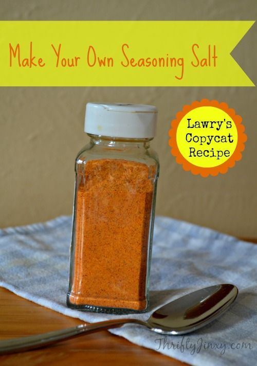 a jar filled with salt sitting on top of a wooden table next to a spoon