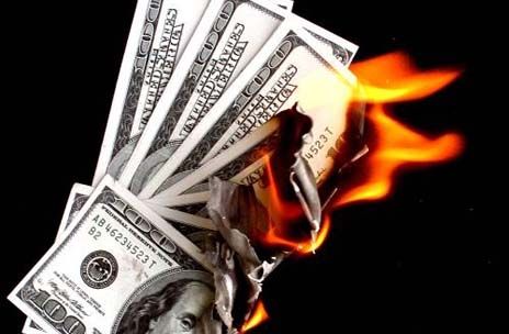 a bunch of money sitting on top of a pile of fire