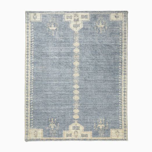 a blue and white rug with an intricate design on the bottom, in front of a white background