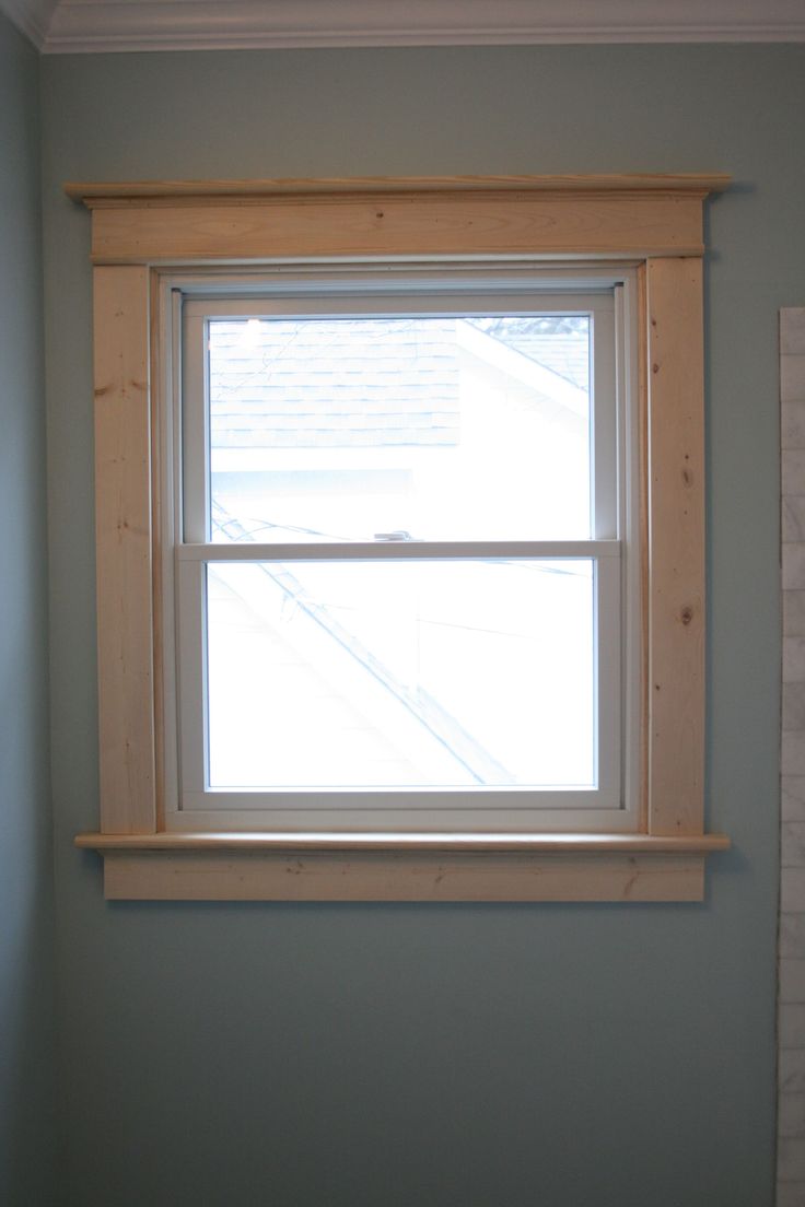 a window in the corner of a room with blue walls and white trim on the windowsill