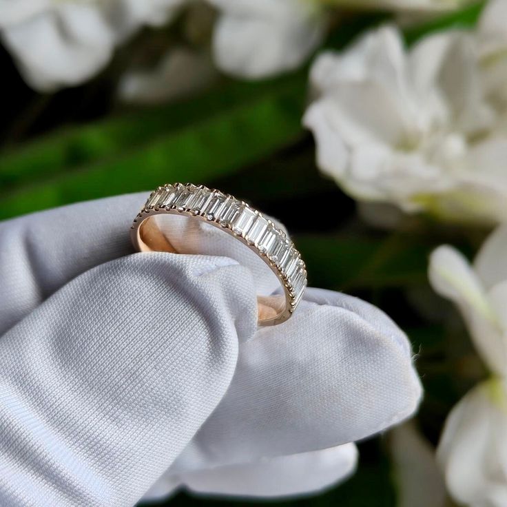 a diamond ring sitting on top of a white glove