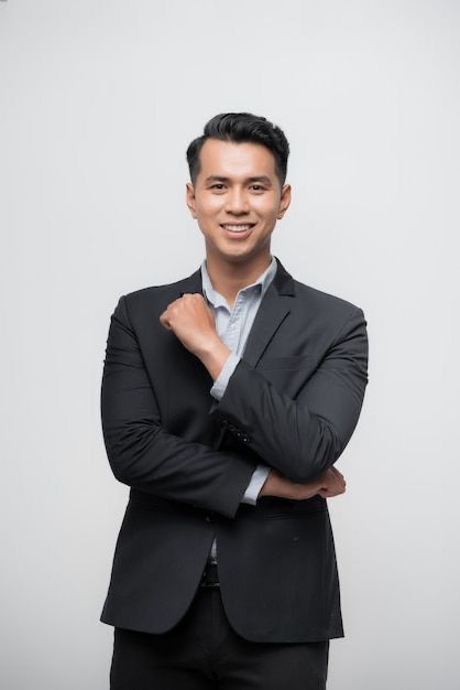 a man in a suit and tie posing for the camera with his arms crossed on his chest