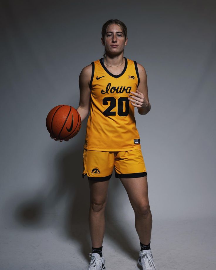 a woman in a yellow uniform holding a basketball