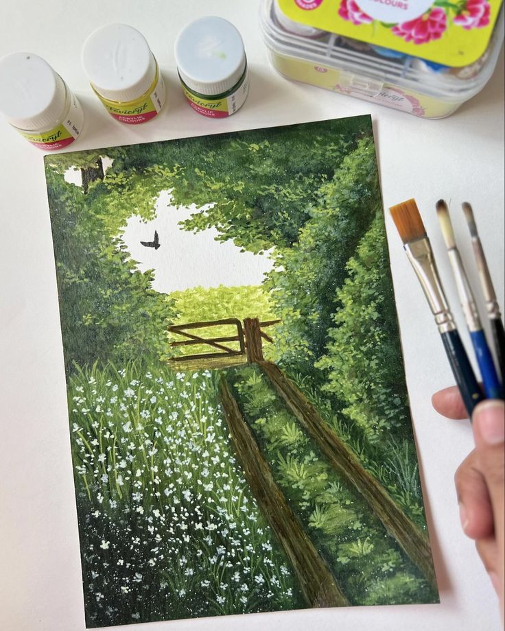 someone is painting a landscape with watercolors