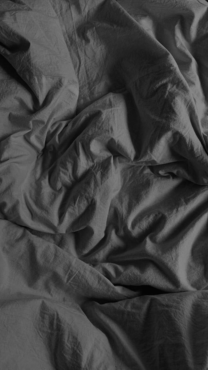 black and white photograph of an unmade bed