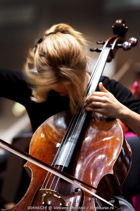 a woman is playing the cello in an orchestra