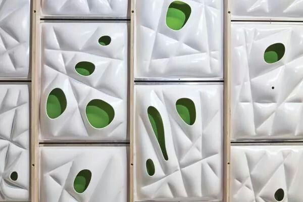 several pieces of art made out of white and green paper with holes in the middle