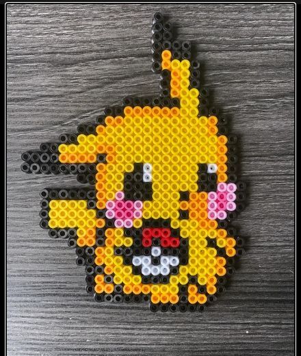 a piece of art made out of perler beads with a pikachu face on it