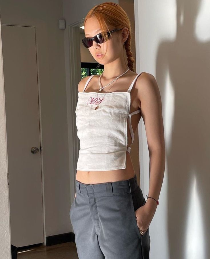 a woman standing in front of a wall with her shadow on the wall behind her