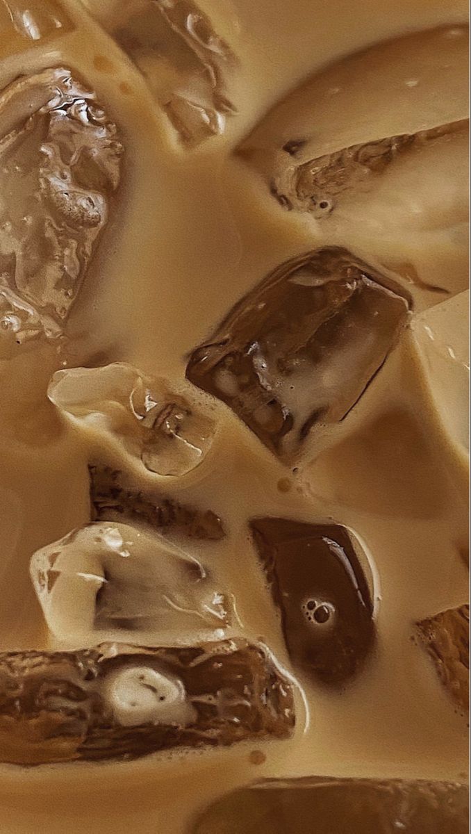 ice cubes are melting on top of each other in brown and white liquid,