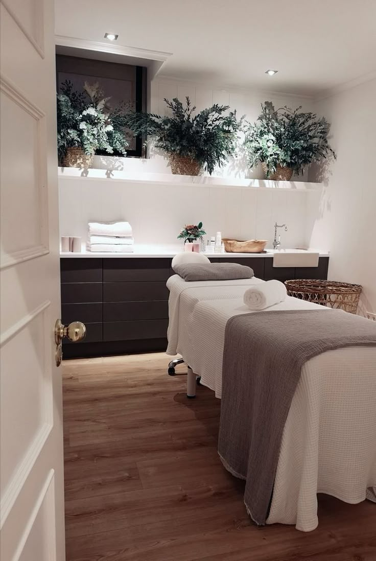 two massage tables with towels on them in a room that has wood floors and white walls