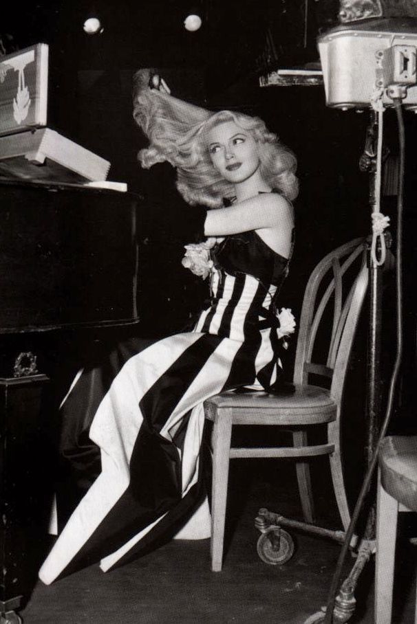 black and white photograph of a woman sitting on a chair with her hair blowing in the wind