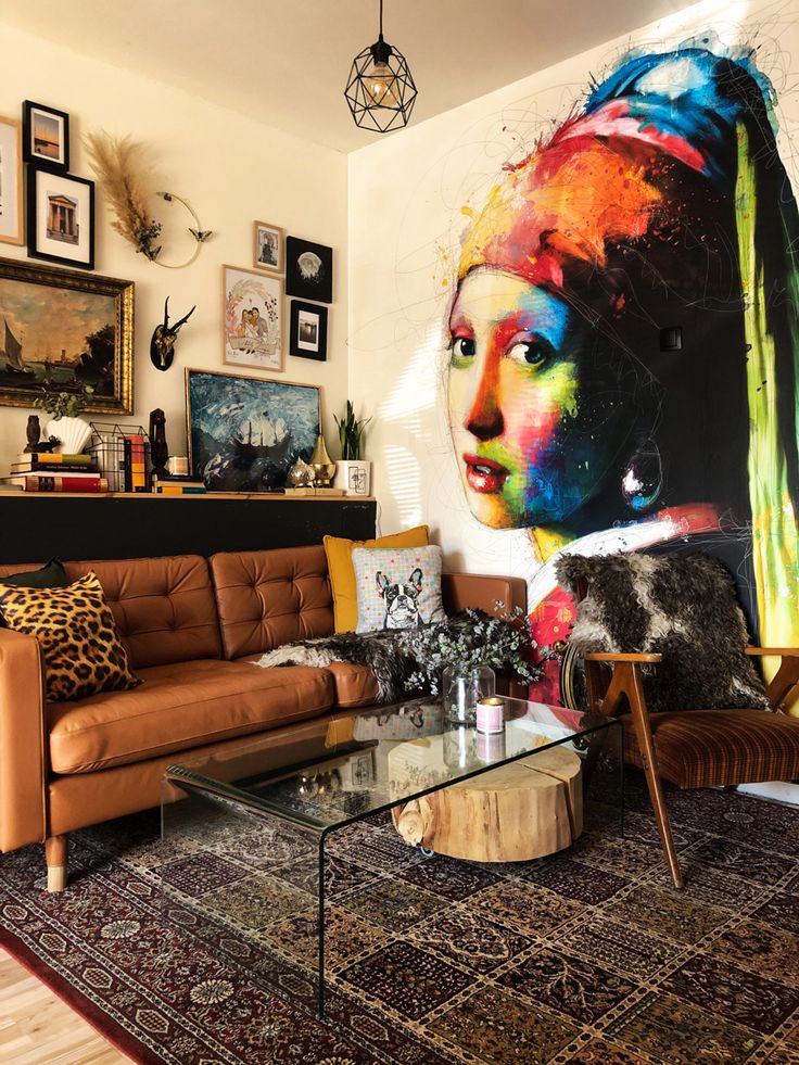 a living room filled with furniture and paintings on the wall above it's coffee table