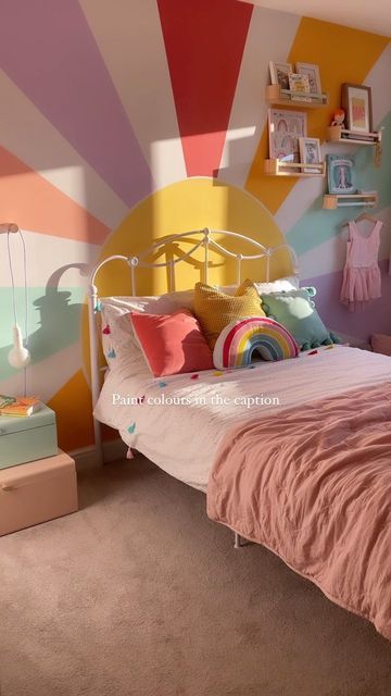 a bedroom decorated in pastel colors and striped walls