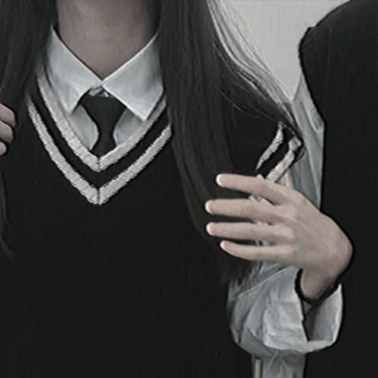 a woman with long black hair wearing a vest and tie