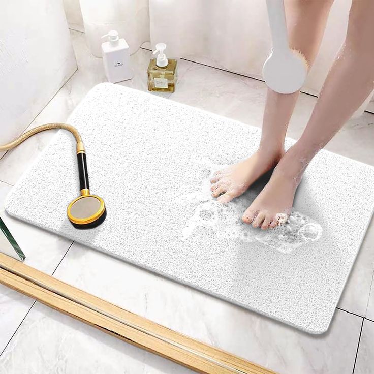 a person standing on a bath mat with a hair dryer next to it