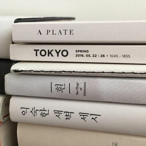 several books stacked on top of each other with japanese characters written on the covers in black and white