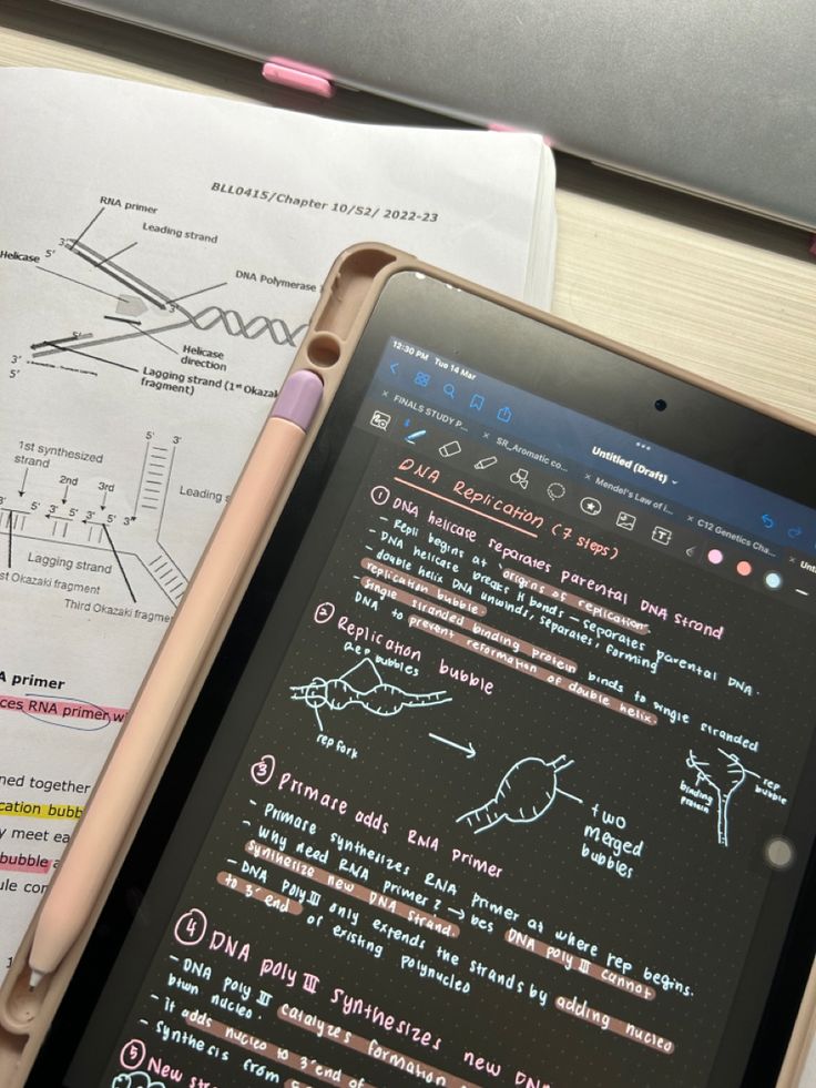 a tablet computer sitting on top of a wooden desk next to papers and pencils