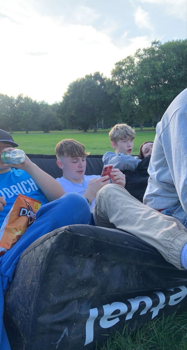 a group of people sitting on top of a field