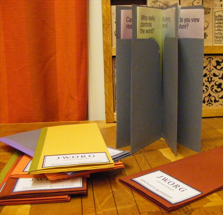 several folders are stacked on top of each other in front of an orange curtain