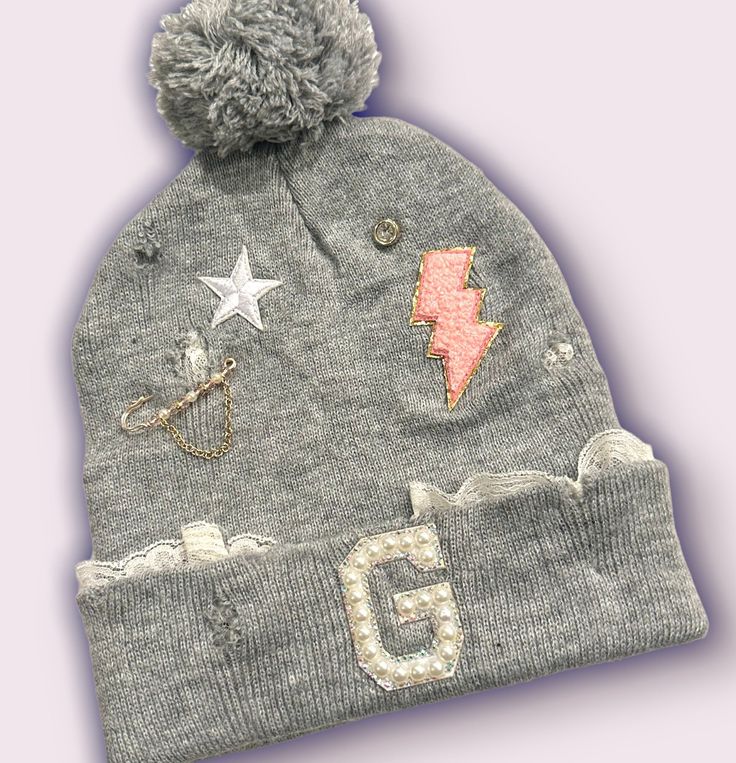 a gray hat with patches and stars on it