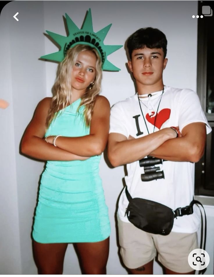 a man and woman dressed up as the statue of liberty, with their arms crossed