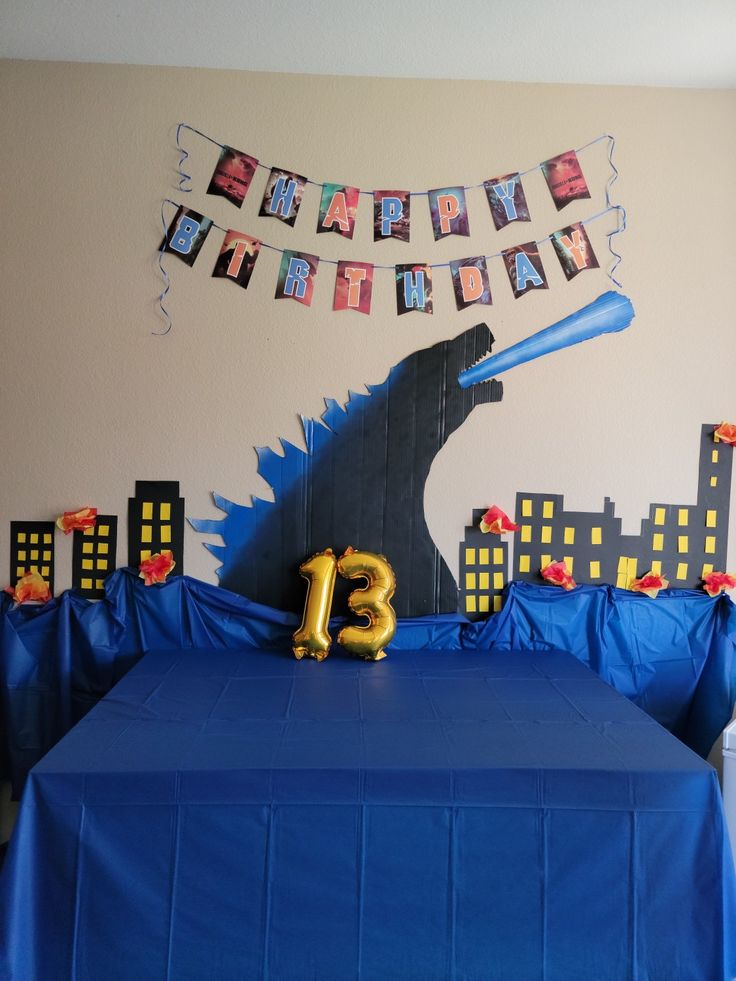 a birthday party with blue table cloths and decorations, including an inflatable number 13