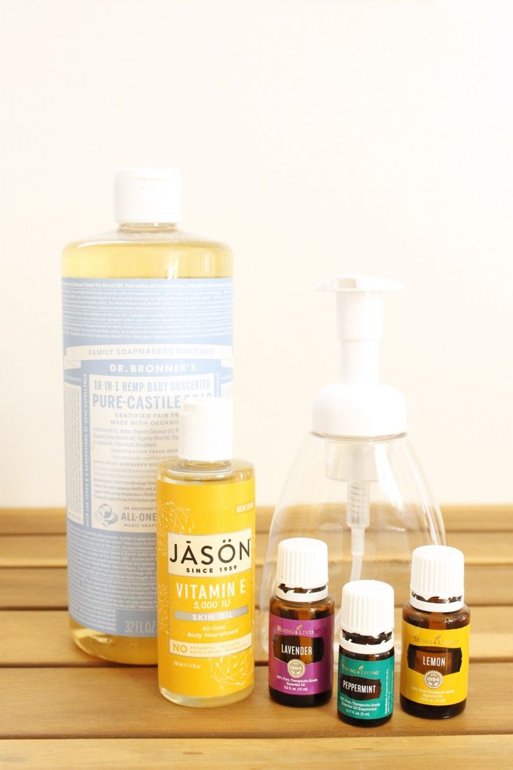 an assortment of essential oils on a wooden table next to a soap dispenser