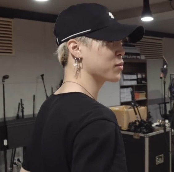 a woman with blonde hair wearing a black baseball cap and earring in a recording studio