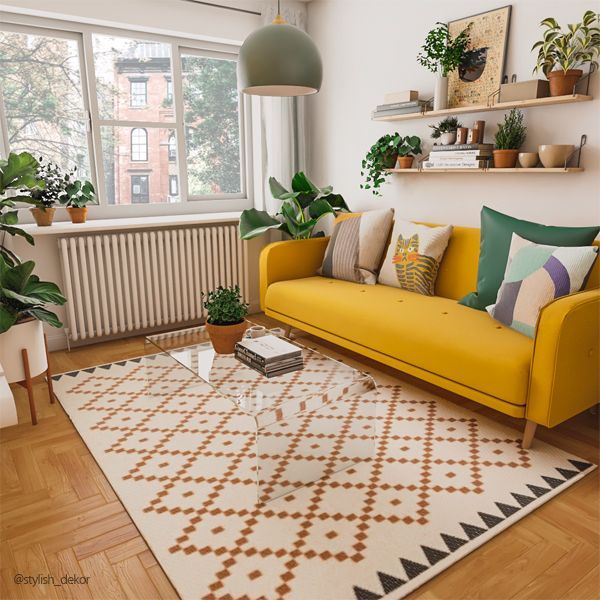 a living room with yellow couches and potted plants on the windowsills