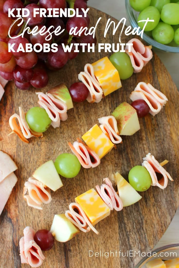 grapes, melon, and other fruits are arranged on a cutting board