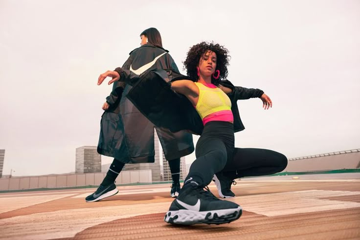 two people are doing tricks on their skateboards in the air, one person is wearing black and yellow