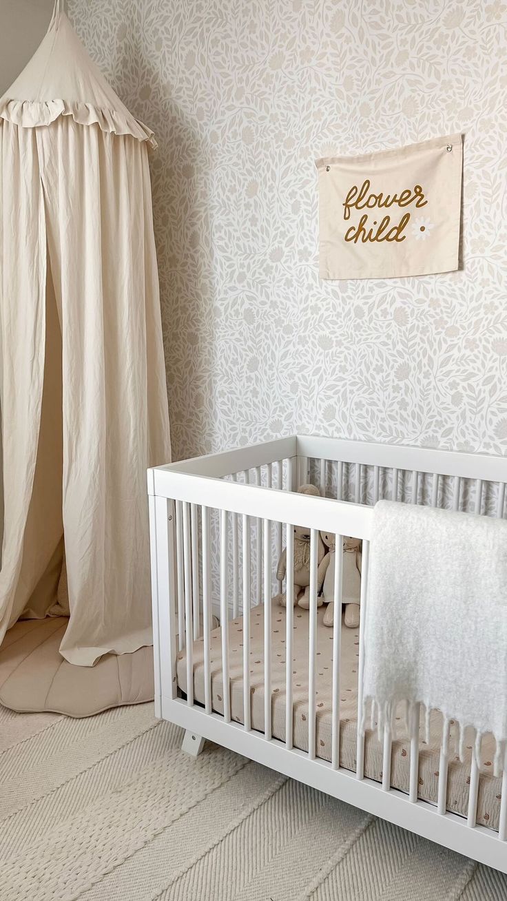 a white crib in a baby's room next to a teepee tent