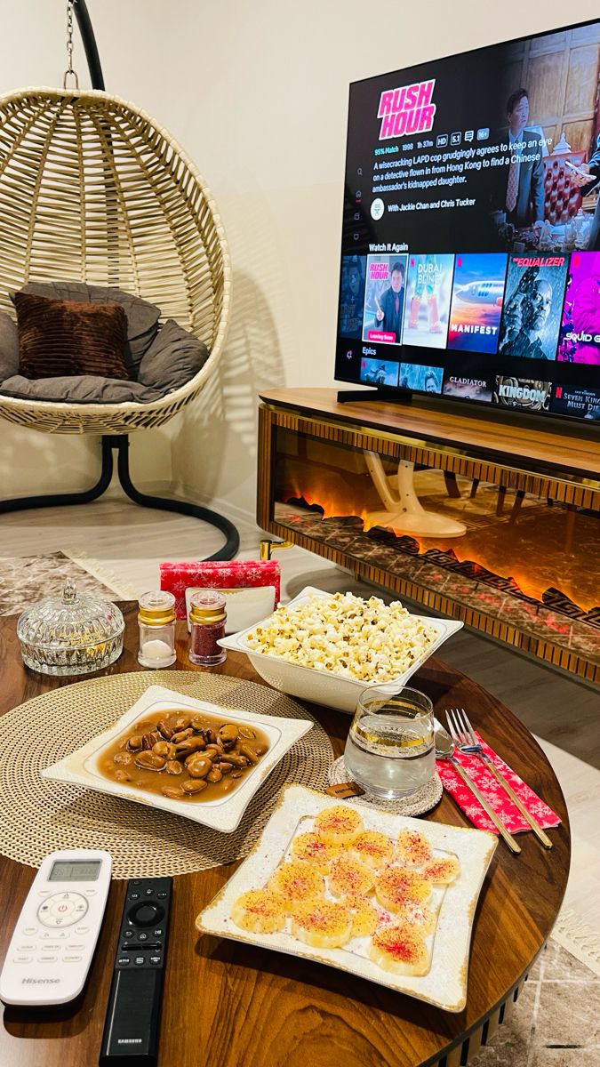 a table with food on it in front of a television and some remotes next to it