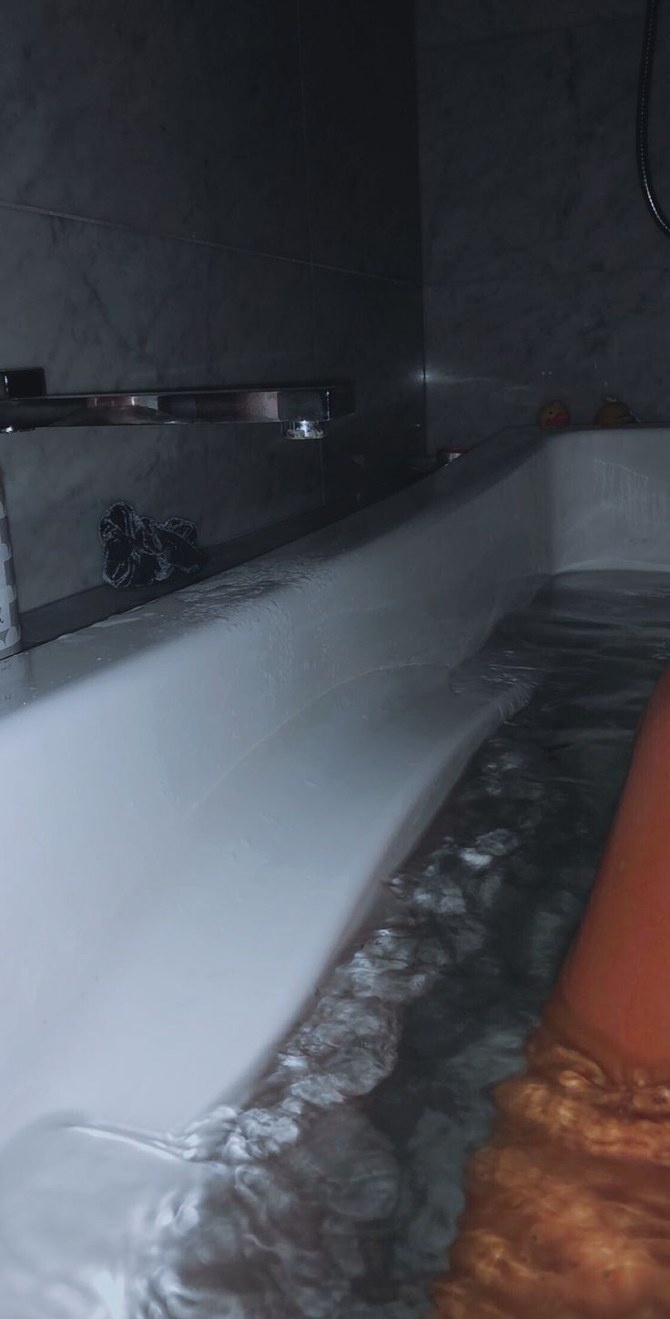 an orange object floating in the water next to a bathtub