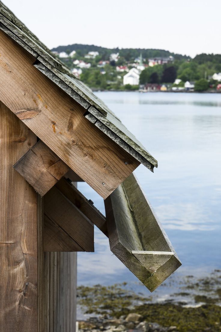 a bird house on the side of a body of water