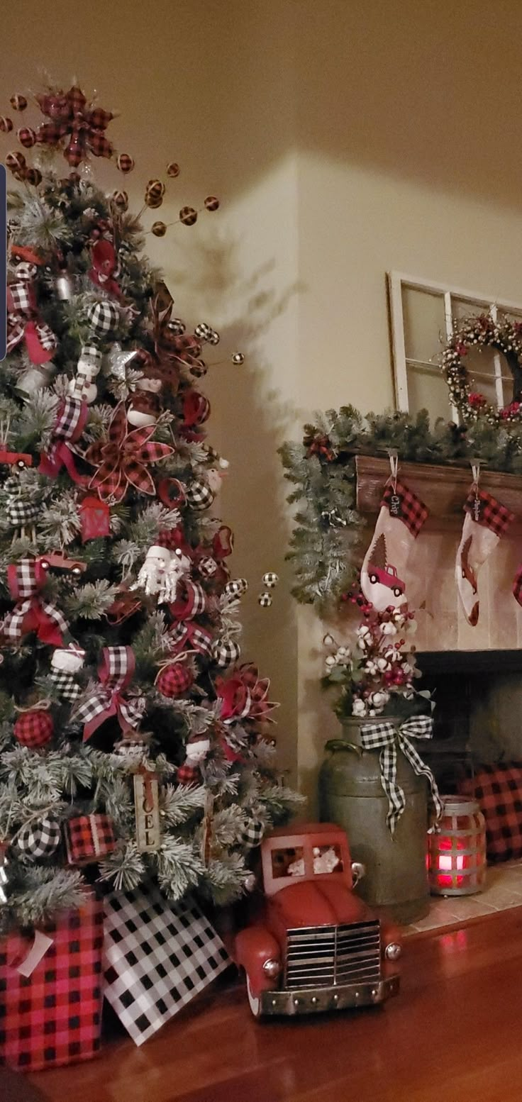 a christmas tree decorated with red and black plaid ribbon next to a fire hydrant