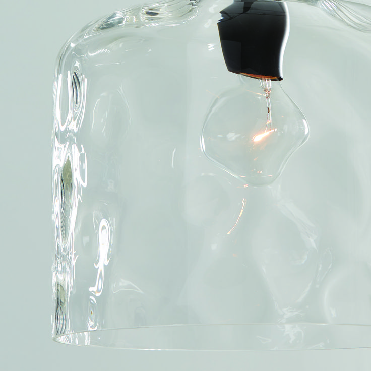 a light bulb that is inside of a clear glass container on a white surface with no one around it