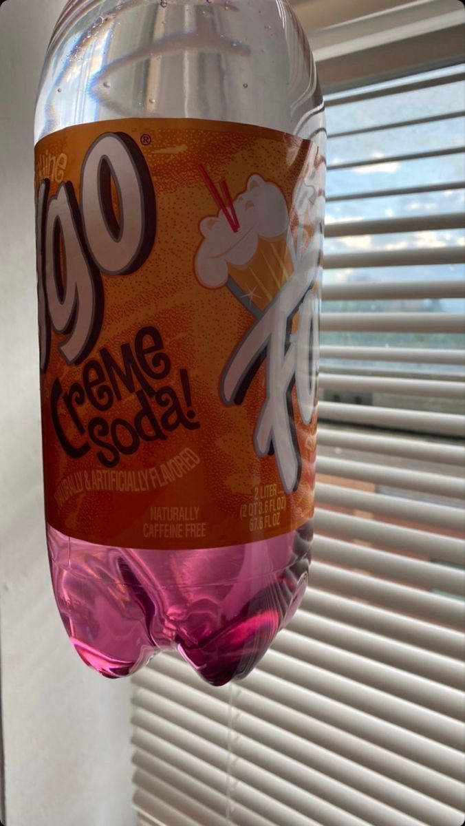 a pink soda bottle hanging from a window sill