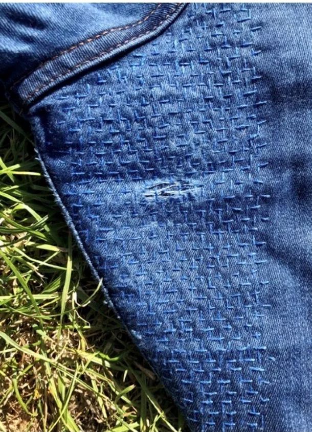 a pair of blue jeans laying on top of grass