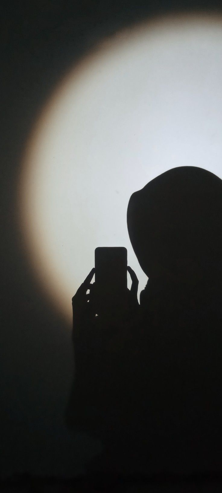 the silhouette of a person holding a camera