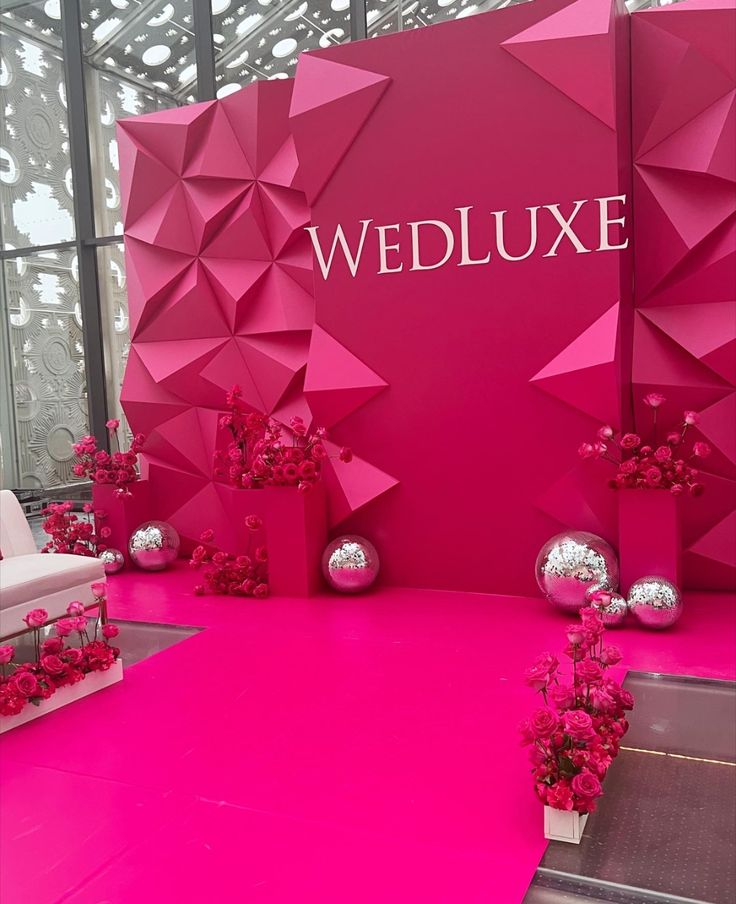 the entrance to wedluxe is decorated with pink flowers