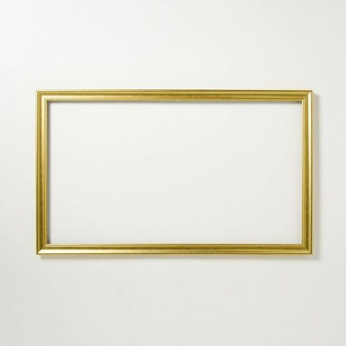 an empty gold frame hanging on the wall