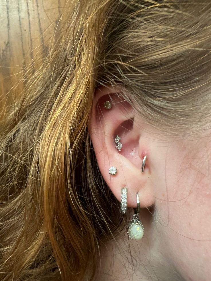 a close up of a person's ear with three different piercings on it