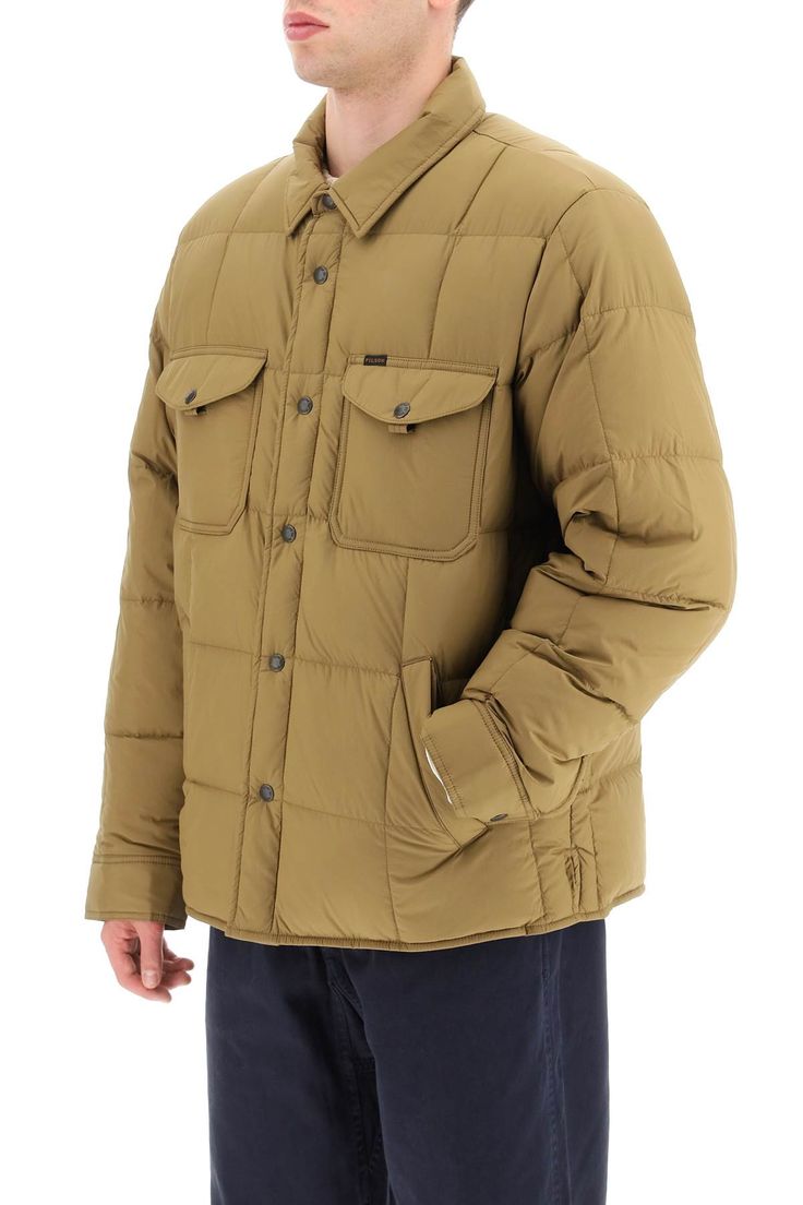 Overshirt-style down jacket by Filson made of a water-resistant nylon fabric with square quilting and slight goose down and feather padding. It features pointed collar, snap button fastening and cuffs, and curved hem with side slits. Handwarmer flannel-lined pockets and chest patch pockets with studded flap. Finished with a mini logo label at chest. Full lining, with two internal pockets. Oversized fit. The model is 187 cm tall and wears a size L. Composition: 100% NY, 100% LO | Filson Men's Lig Filson Mens, Quilted Jacket Men, Man Quilt, Mini Logo, Mini Logos, Lightweight Quilt, Dark Tan, Nylon Fabric, Quilted Jacket