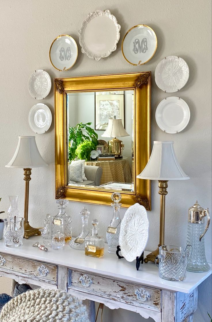 a white table topped with a mirror and lots of plates