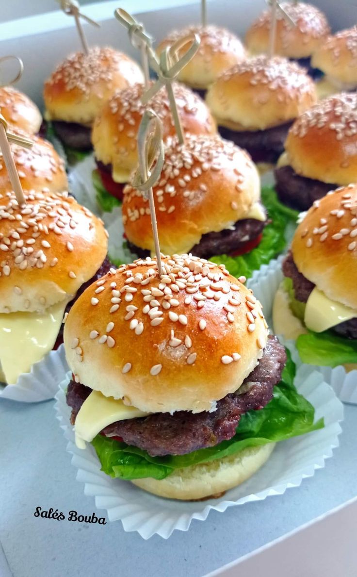 mini hamburgers with cheese and lettuce on them